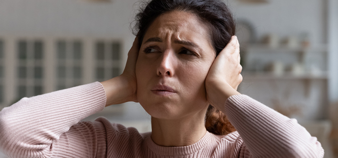 woman covering her ears
