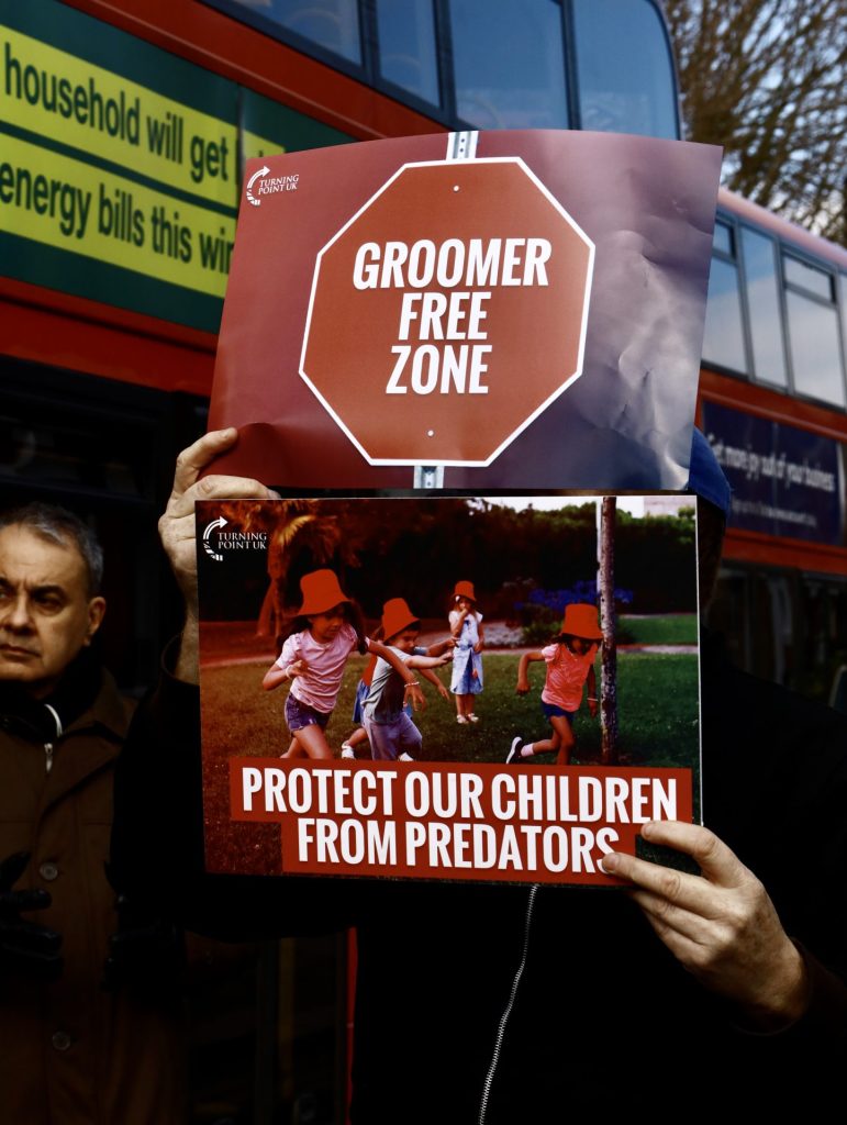 Far right wing protesters hold placards