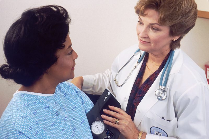 doctor taking patient blood pressure