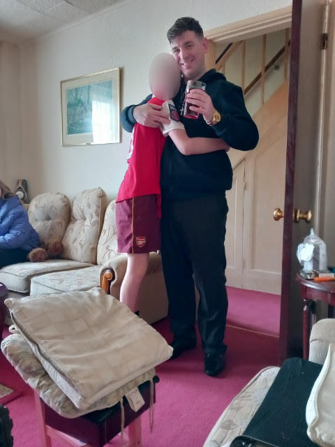 Lawrence at his family home with one of his younger siblings after being released.