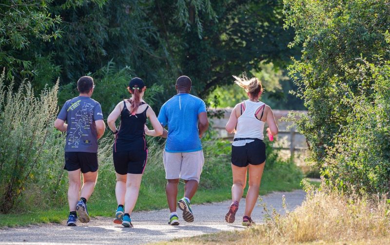 Four people running through the park