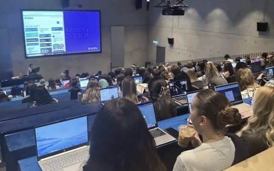 Crowded Greenwich university lecture students having to sit on the ground with no desk as they have nowhere to sit.