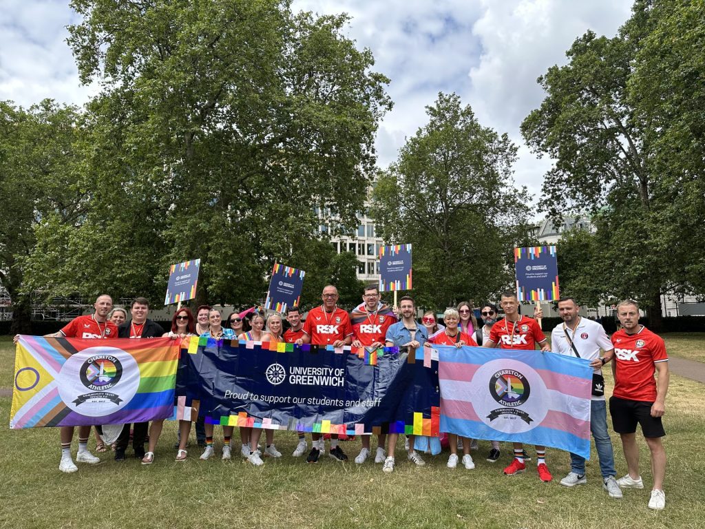 A photo of Charlton Invicta Football Club holding rainbow flags.