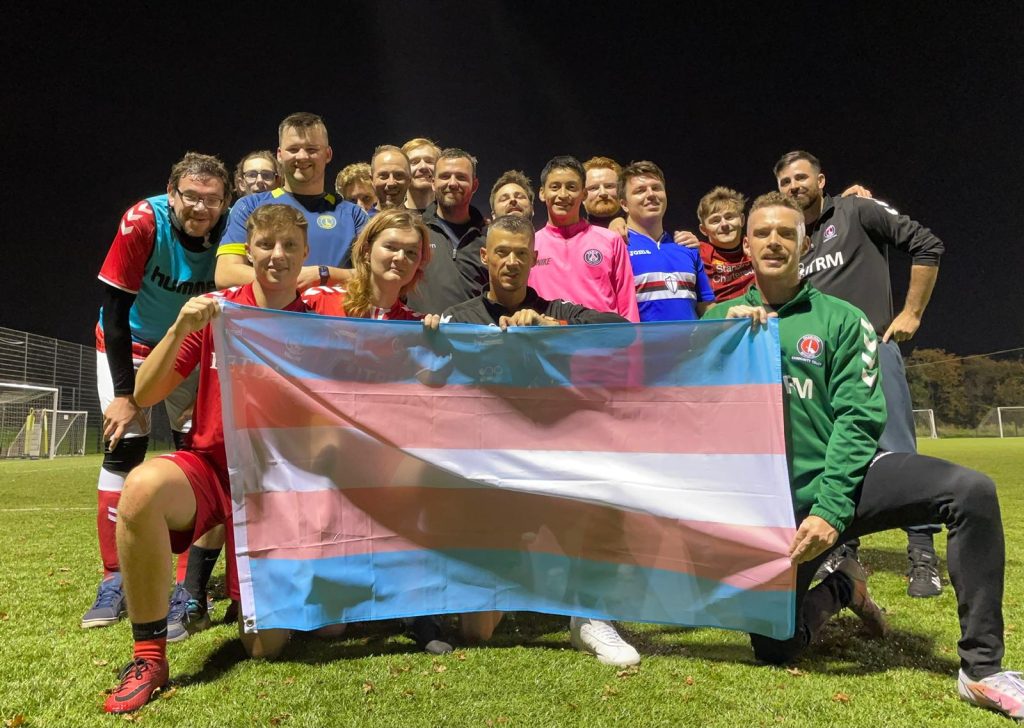 Members of Charlton Invicta Football Club holding the transgender flag.