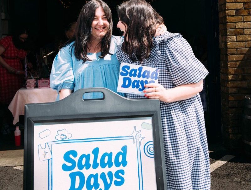 Tinker twins with a sign for their market