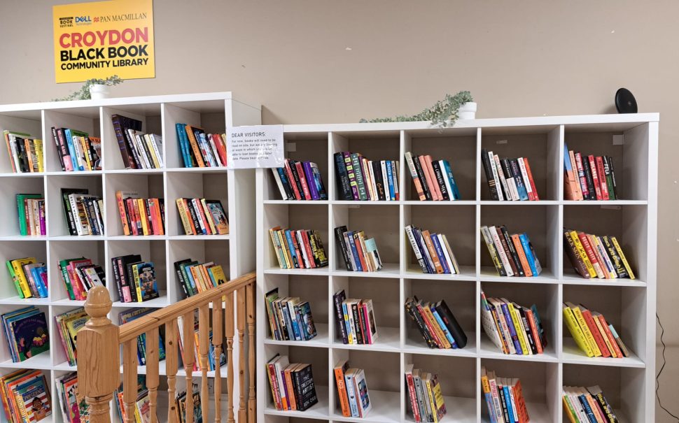 Image showing the inside of the Community Black Book Library in Croydon, located at the Croydon BME Forum in the Whitgift Shopping Centre. There are two large white book cases filled with a variety of different books written by Black authors.