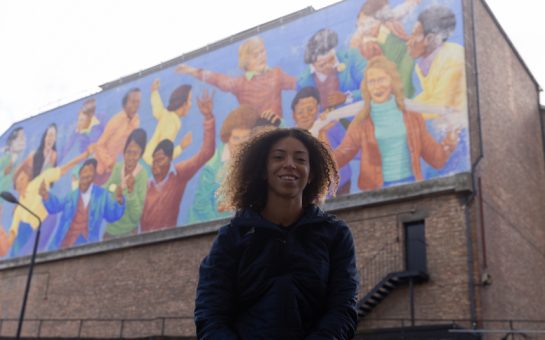 GB Hockey athlete promotes diversity standing outside the children at play mural in Brixton