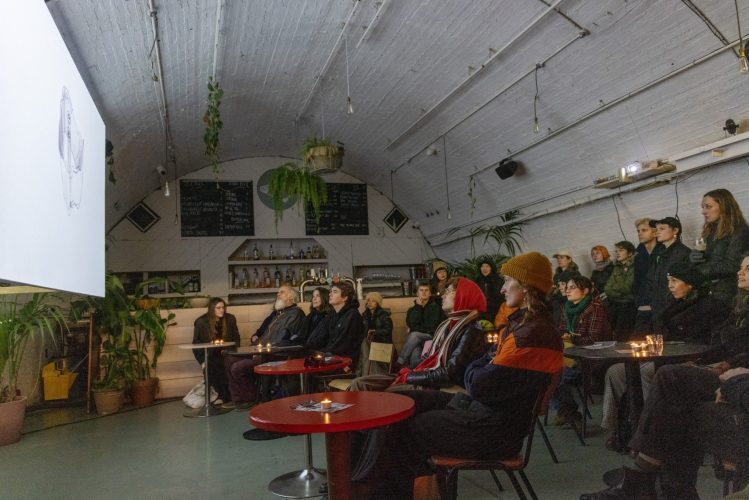 Room of people watching a film at Peckham Arches, London.