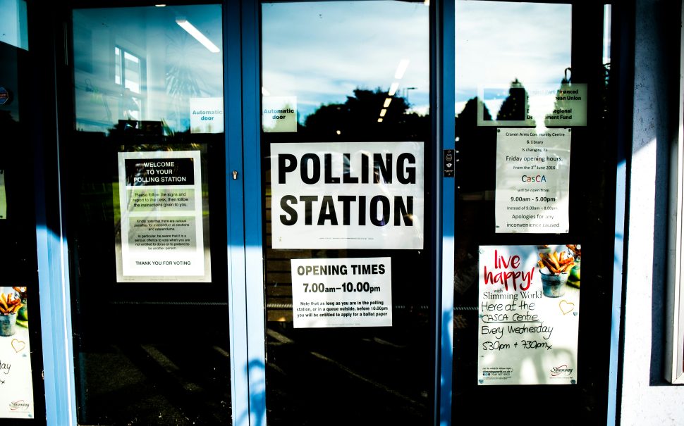 A picture of a polling station sign on a door.