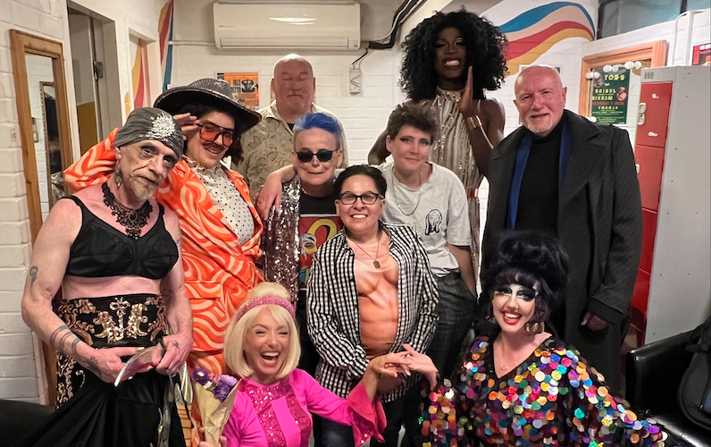 A landscape group photo capturing the performers of Songbook in their various costumes. They are smiling at the camera.