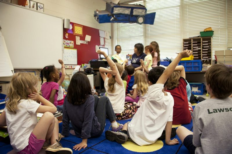 A group of children with their hands up