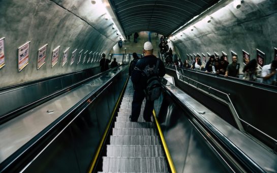 Image of commuters travelling down a TfL escalator. (Picture credit: Kaique Rocha)