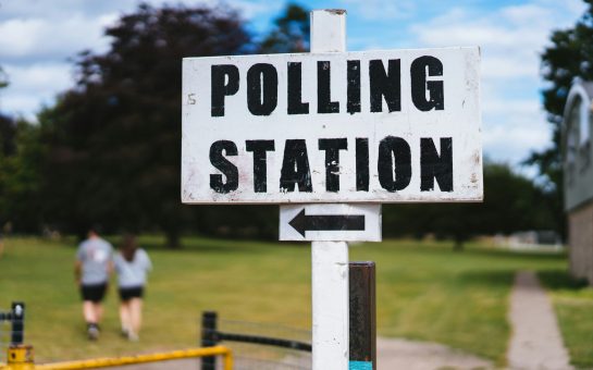 White polling station sign on a flagpole