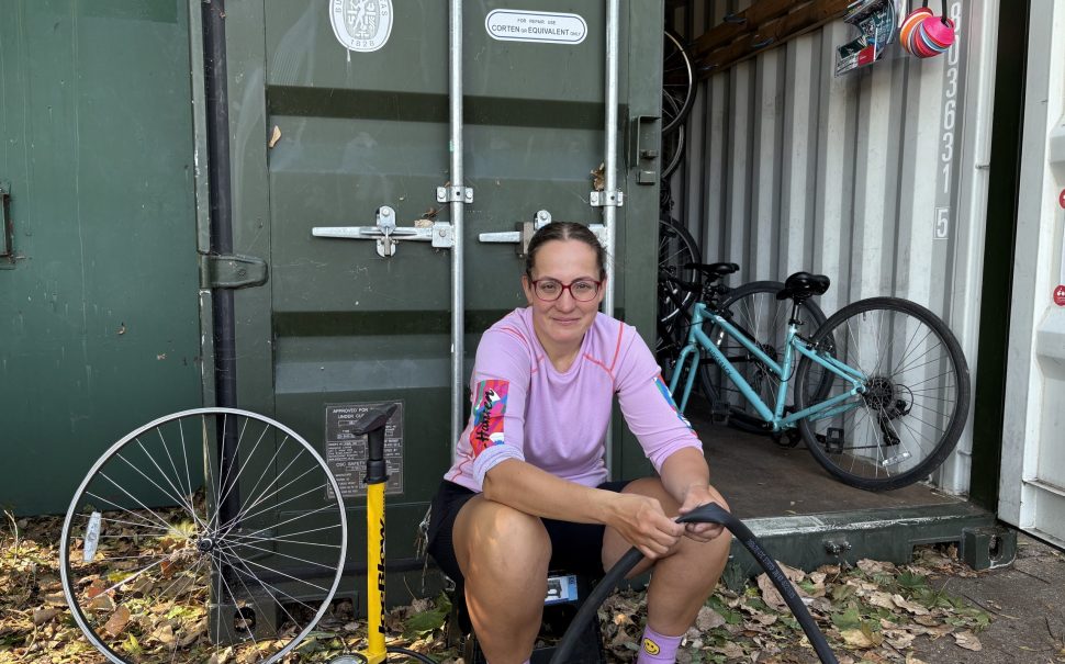 Cycling Instructor Enikő Szabó fixing a JoyRiders bike outside Burgess Park storage unit