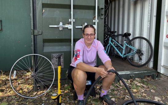 Cycling Instructor Enikő Szabó fixing a JoyRiders bike outside Burgess Park storage unit