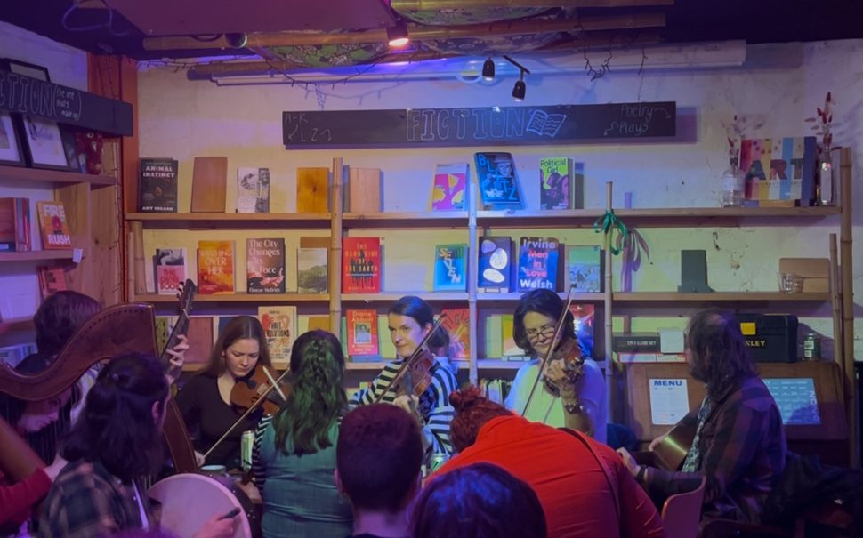 Photo: the bookshop, with the folk music night in full swing. Customers enjoying themselves in the foreground, musicians playing violins in the background