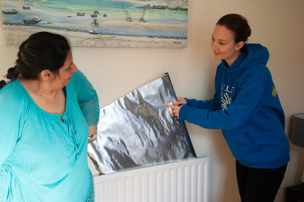 A SELCE member shows someone how to insulate their home better.