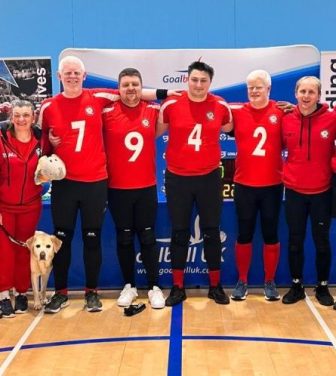 A photo of the London Elephants Goalball team in a sports hall.