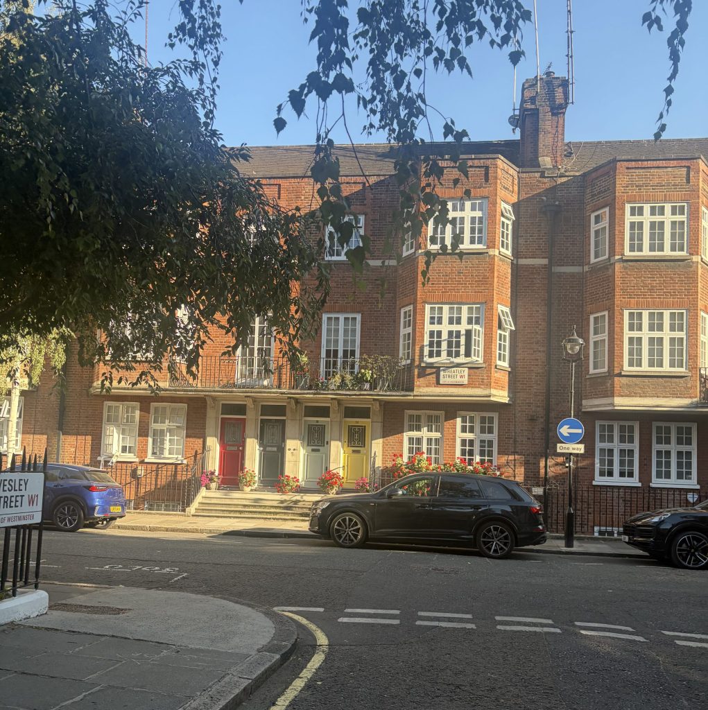Quiet residential stretch of Wheatley Street in Marylebone, with red-brick homes and parked cars
