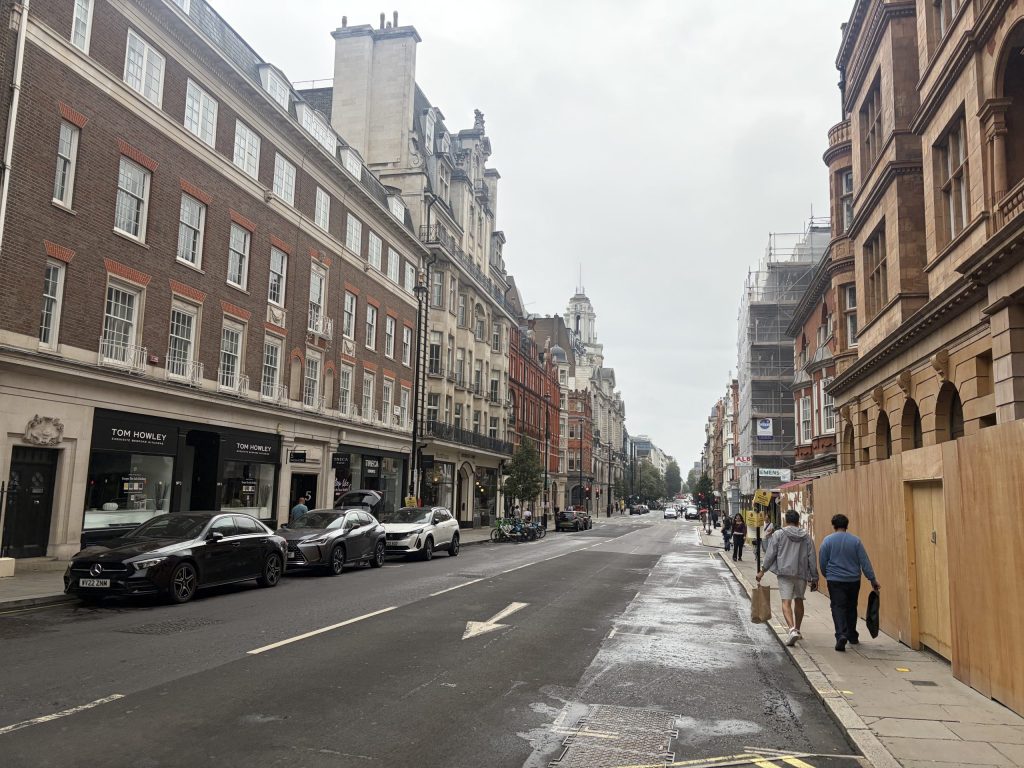 View along Wigmore Street in Marylebone, with cars, pedestrians and building works near Oxford Street
