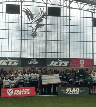 NFL New York Jets launch event with Palace for Life Foundation. Eight schools in attendance with 90 pupils facing camera behind advertising boards.