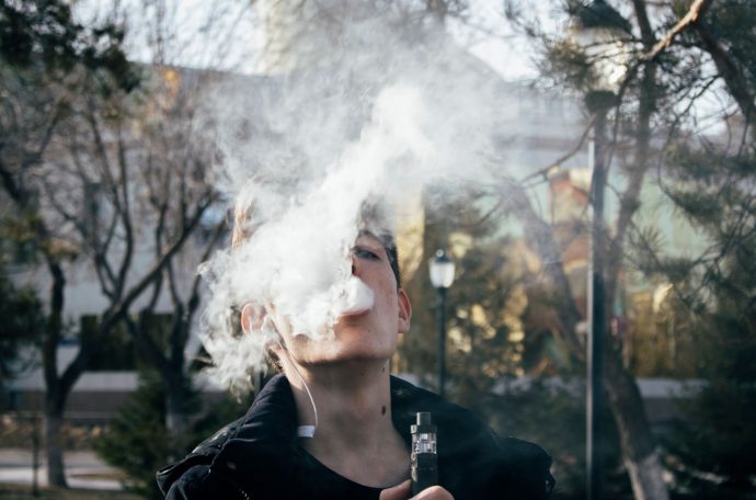 Teen vaping in a park