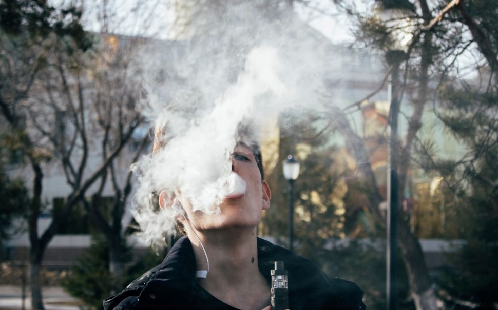 Teen vaping in a park